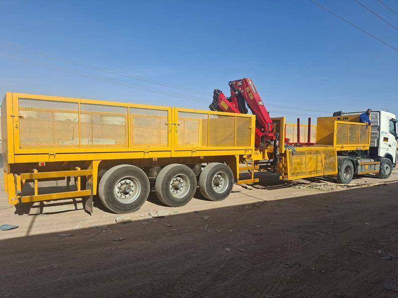 Yellow semi-trailer fitted with an HC 250 knuckle crane for load handling Yellow semi-trailer fitted with an HC 250 knuckle crane for load handling