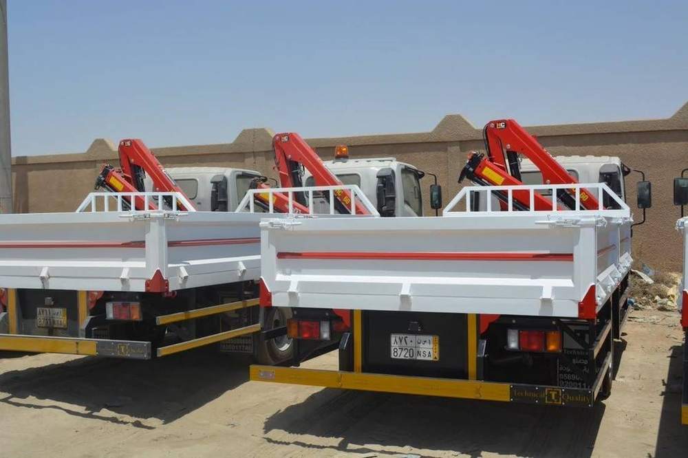 Two trucks with knuckle boom cranes and cargo bodies ready for handover Two trucks with knuckle boom cranes and cargo bodies ready for handover