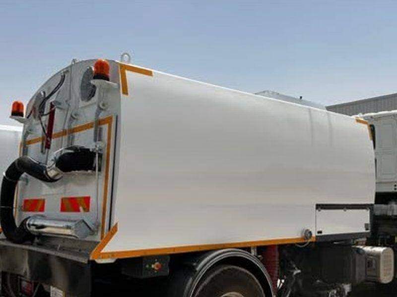 Rear view of a road sweeper showing the hand suction hose and warning lights Rear view of a road sweeper showing the hand suction hose and warning lights